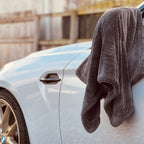Gray towel draped over a white car door with a blurred background